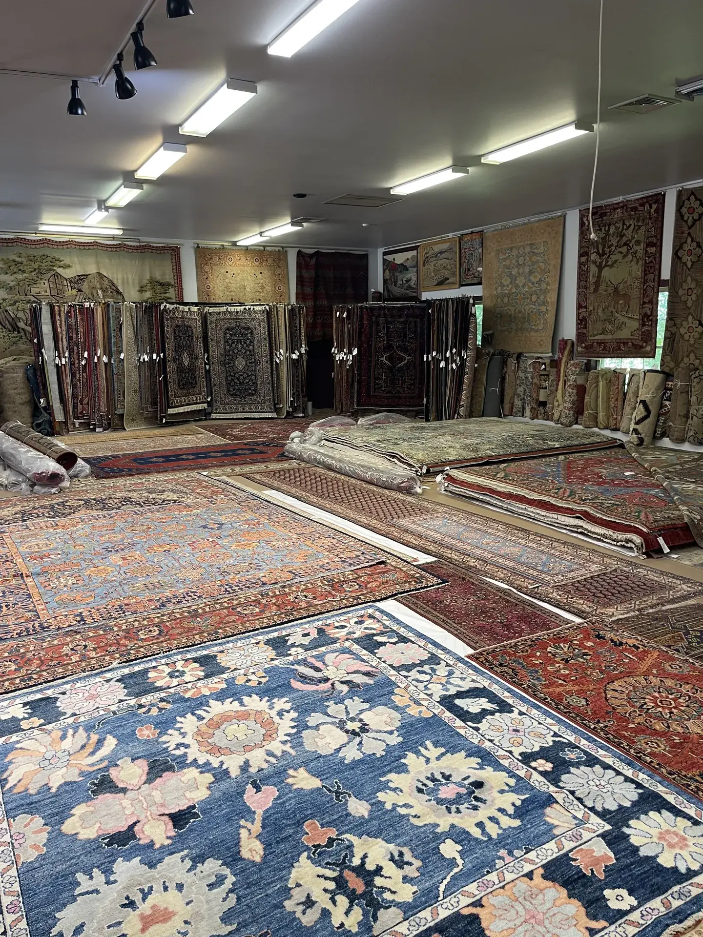 Rows of patterned rugs inside the Woodbury gallery